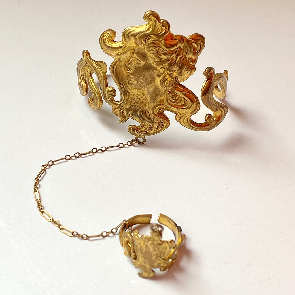 photo of elaborate gold cameo bracelet with gold chain connecting it to matching gold cameo ring, also elaborate