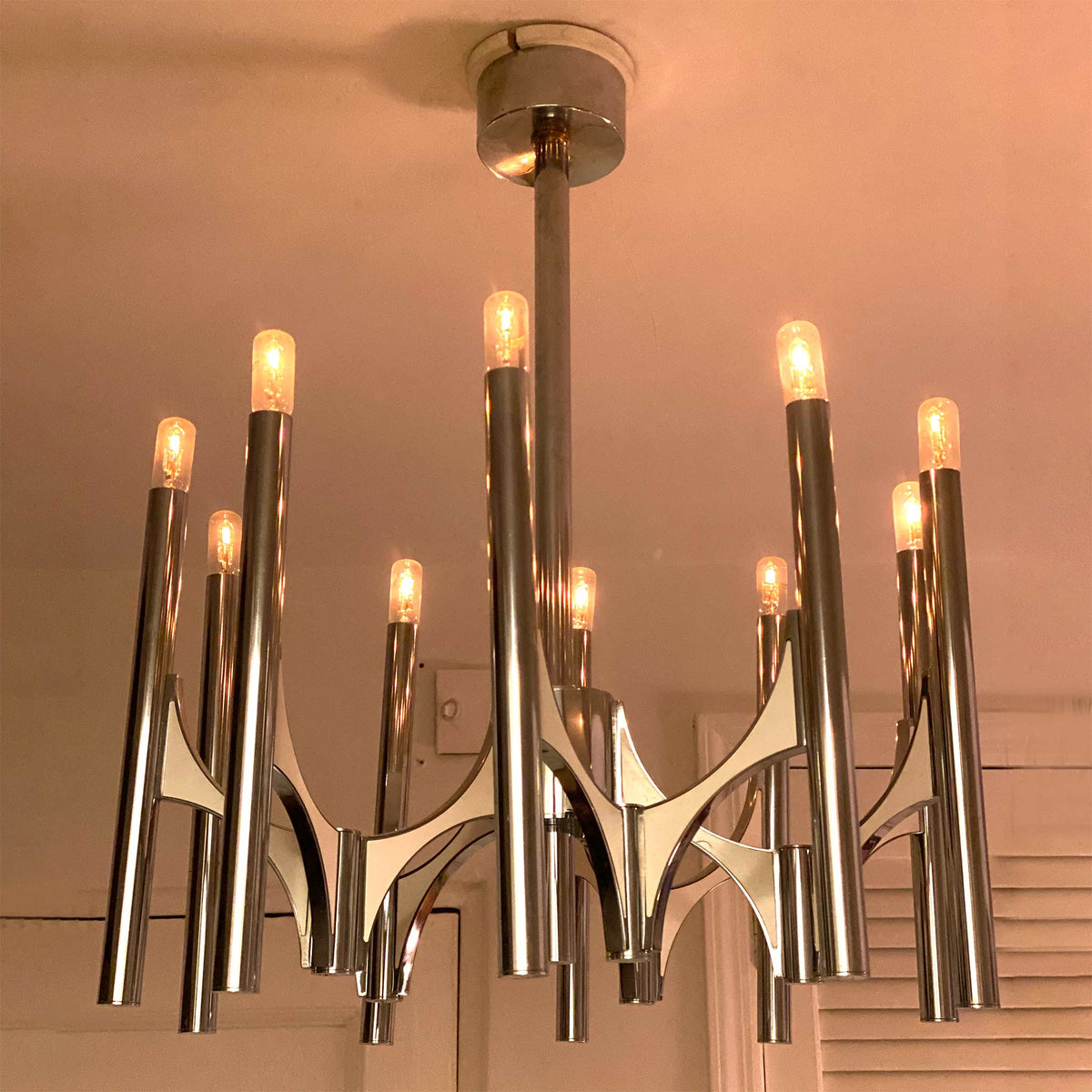 photo of 10-lamp chrome chandelier with lamps dimmed down for warm candlelight-like effect from mindscapade