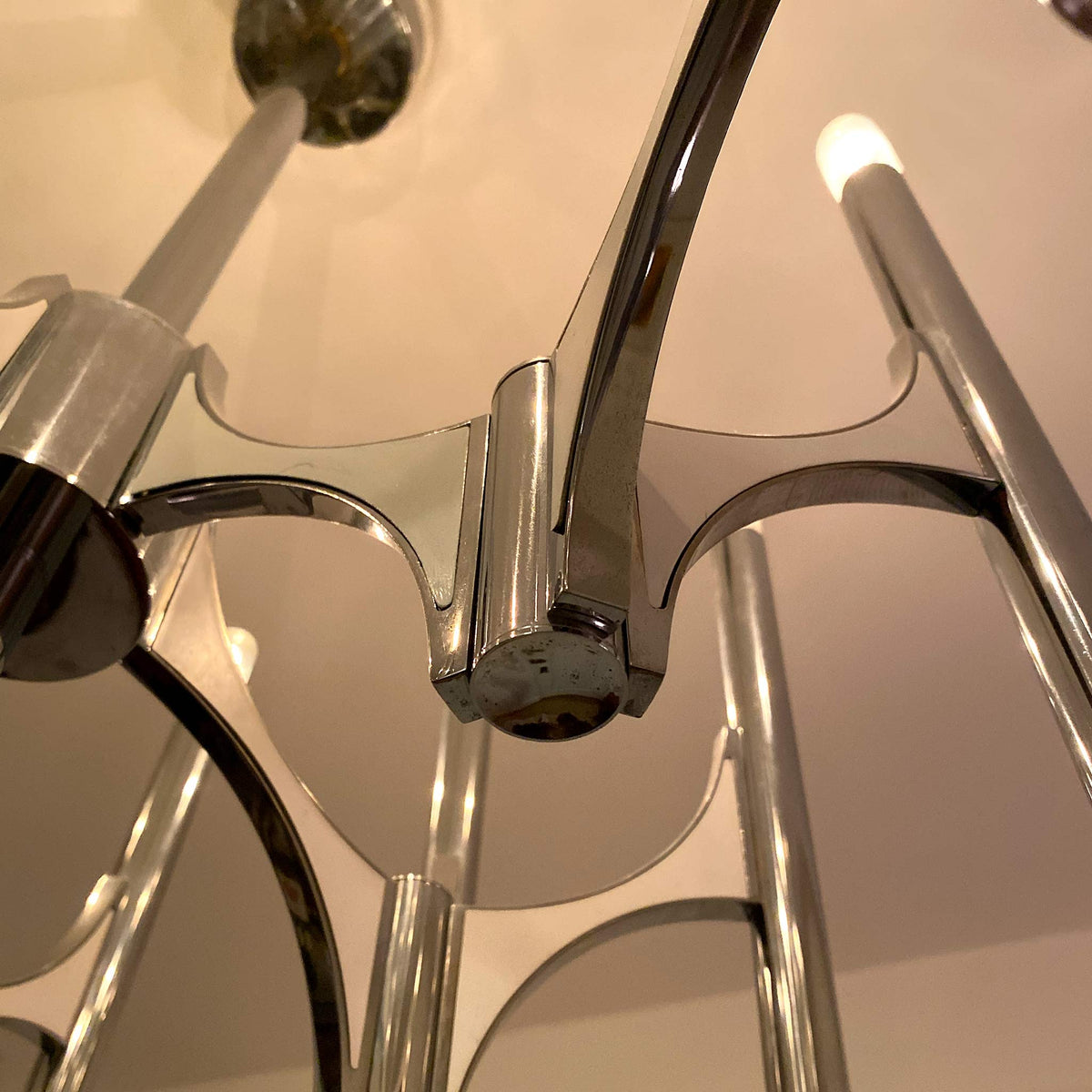 photo of 10-lamp chrome chandelier close up showing one pair of lamps attached to flying buttress-like arm from mindscapade