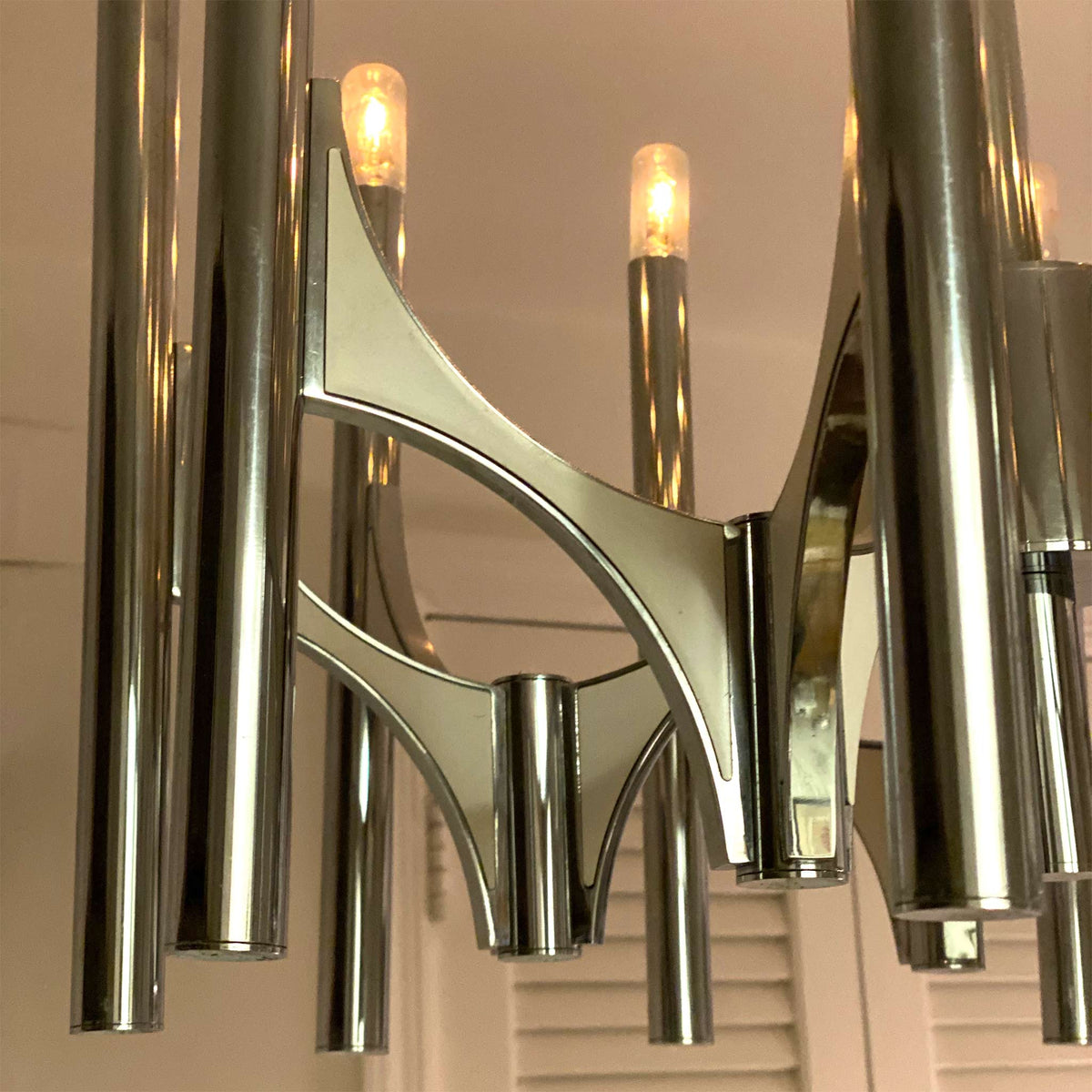 photo of 10-lamp 1960s chrome chandelier featuring lamps at the top of chrome tubes attached in pairs to flying buttress-like arms from mindscapade