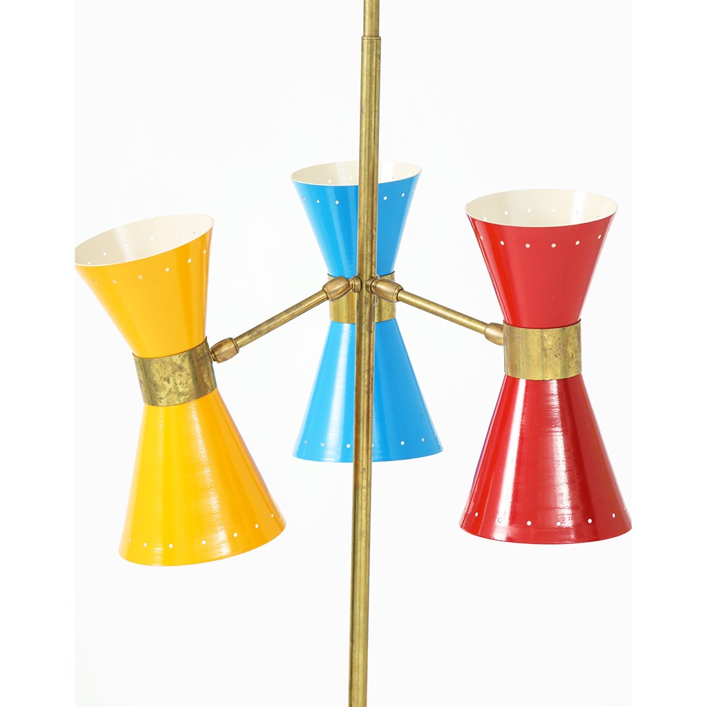 three brightly painted lamps attached to single post of brass colored floor lamp, each lamp having two opposing flared lampshade fixtures