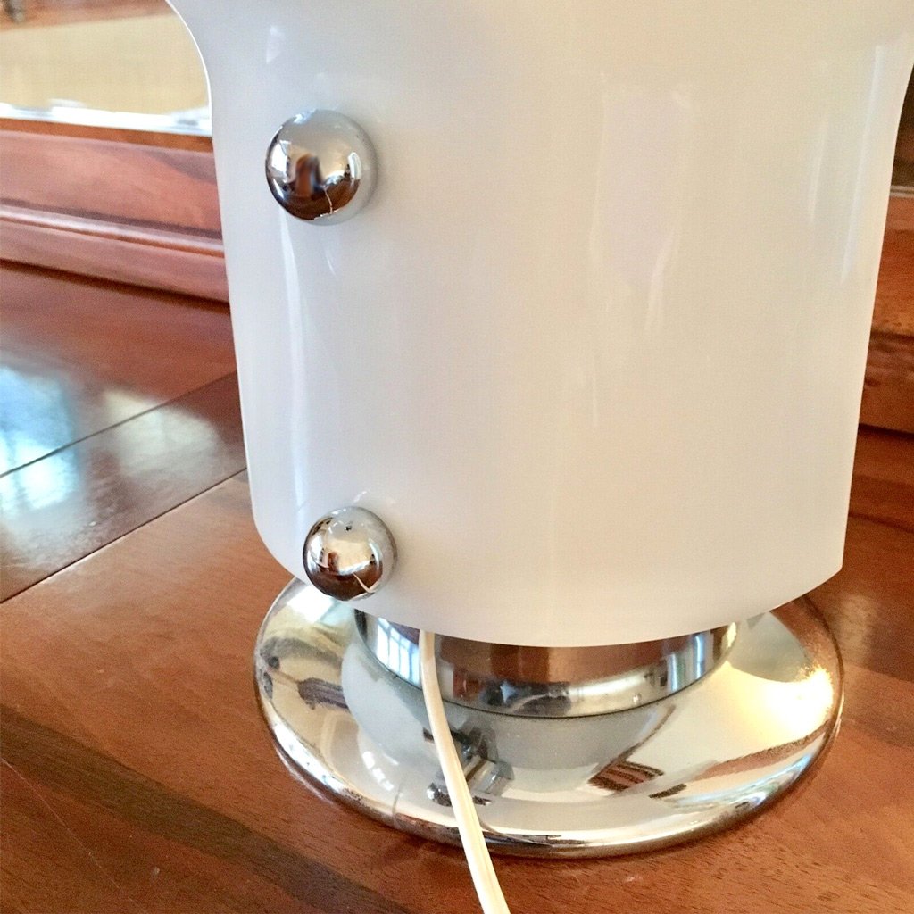 photo of unique stilnovo leuke lamp showing lower rear portion of opal acrylic shade atop heavy chrome base from mindscapade